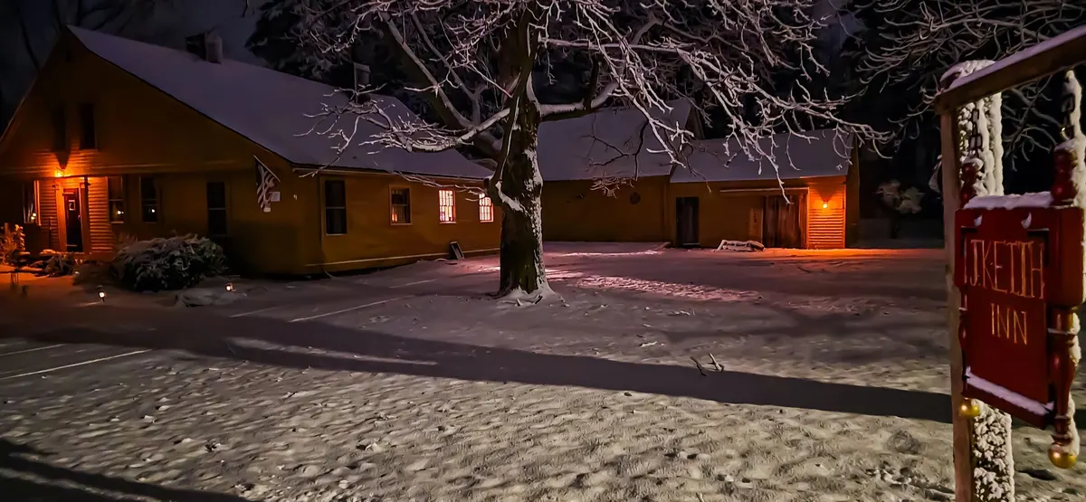 The Josiah Keith House glowing at night after a snowfall
